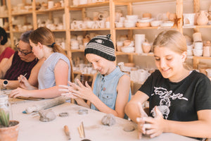 Group of kids making pottery together in class, Nambour