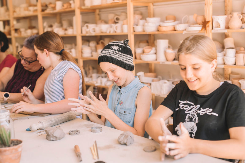 Group of kids making pottery together in class, Nambour