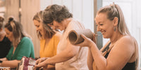 Smiling women hand building pottery together in class, Nambour