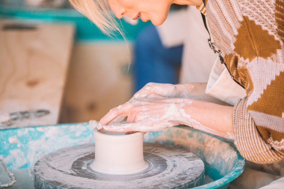 Lifting the walls of a pot on the pottery wheel, Nambour