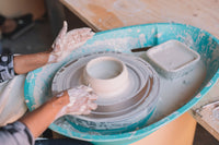 Student throwing pottery on the wheel, beginner class, Nambour